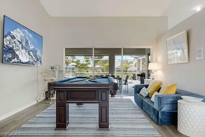Vaulted ceilings, wood-finish flooring, and expansive glass sliders providing outdoor access