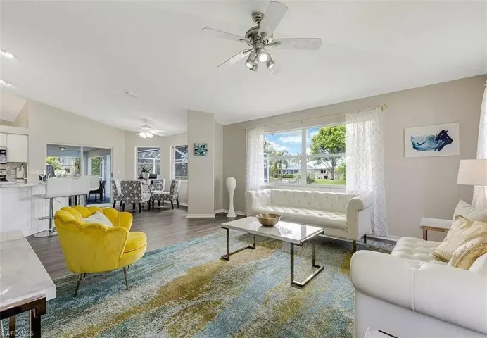Vaulted ceilings, wood-finish flooring, and a dining area with a ceiling fan