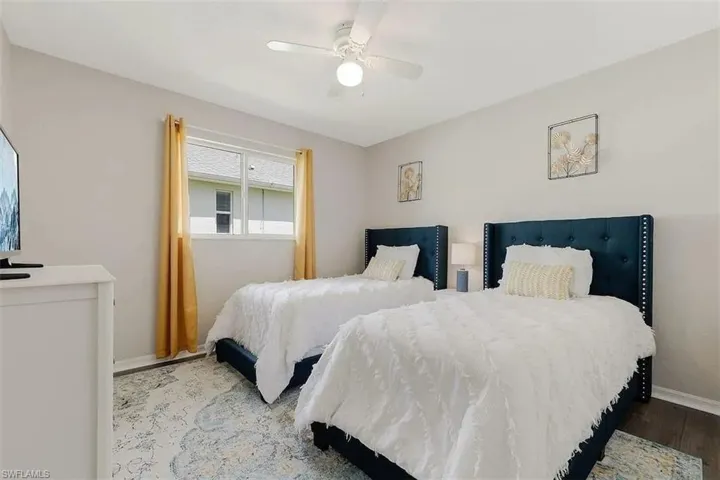 Ceiling fan, window with natural light, dark wood-finish flooring