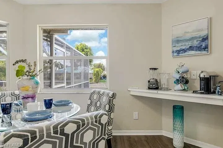 Wood-finish flooring, multiple windows, built-in shelving, and neutral wall tones