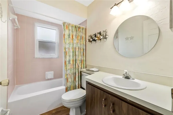 Full bath featuring shower / bath combination with curtain, vanity, and toilet
