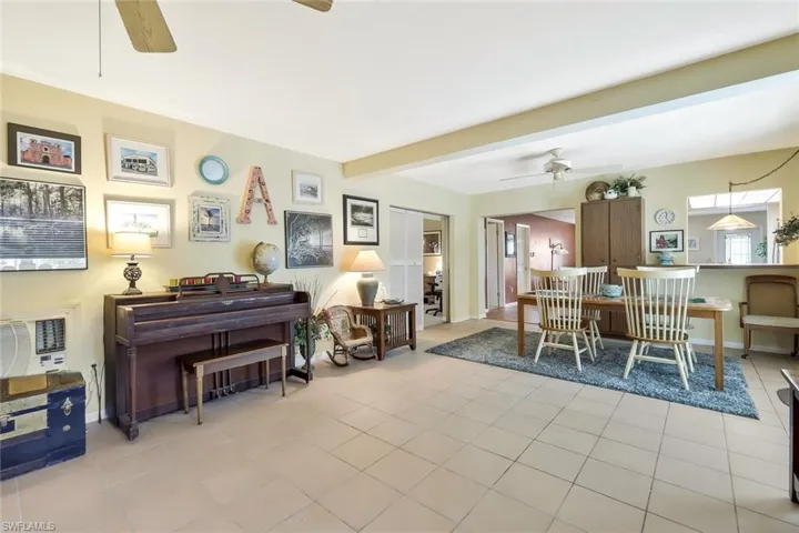 Tiled dining area featuring beam ceiling, and ceiling fan