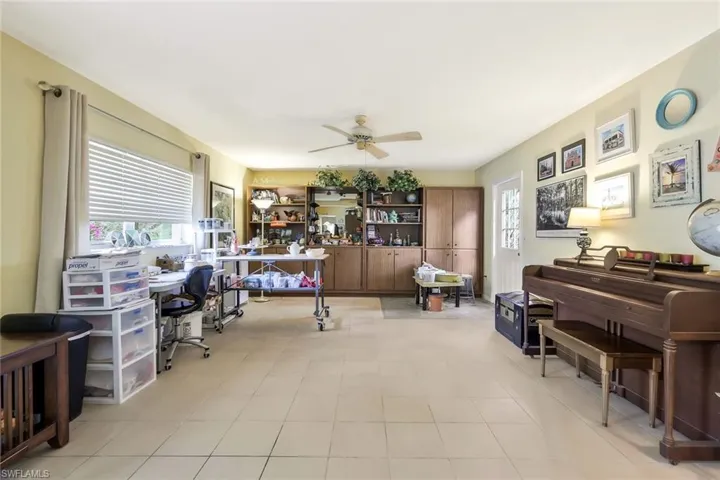 Home office currently used as a studio featuring ceiling fan and light tile patterned flooring