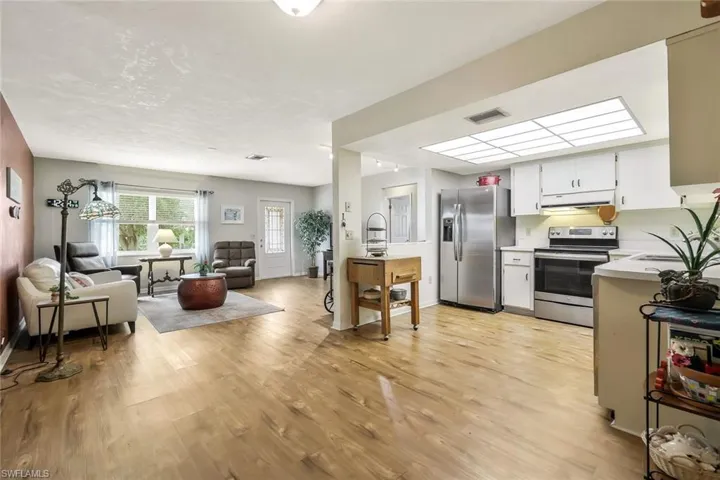 Kitchen with open floor plan, stainless steel appliances, light countertops, under cabinet range hood.