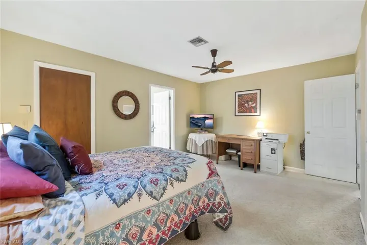 Carpeted bedroom with a ceiling fan.