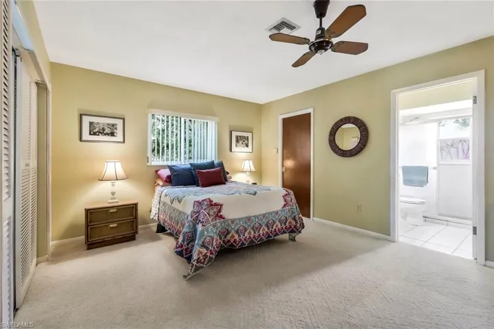Main carpeted Bedroom featuring ceiling fan and ensuite bathroom.