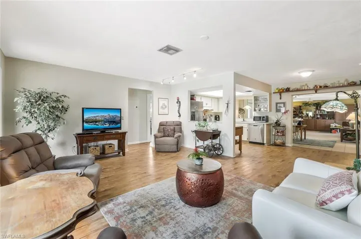 Living area with track lighting, and light wood finish floors