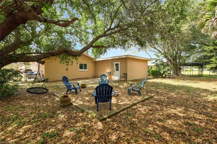 Rear view of large property featuring an outdoor fire pit