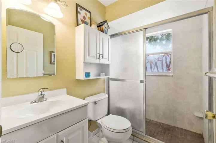 Full bath with vanity, toilet, and a stall shower