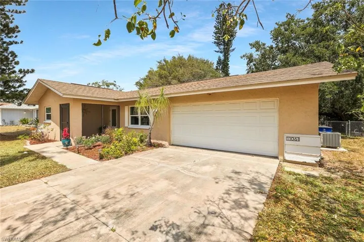 Ranch-style house with central AC unit, fence, concrete driveway, stucco siding, and a garage