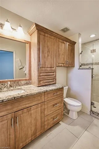 Bathroom featuring Cornerstone Tile and Marble vanity, a stall shower, tile patterned floors, and a textured ceiling