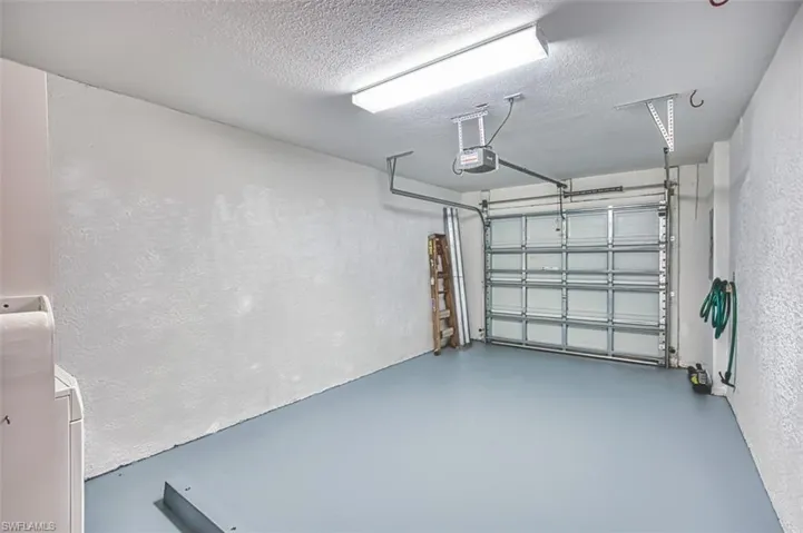 Garage with a garage door opener and a textured wall