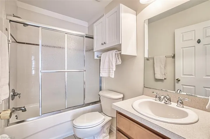 Bathroom featuring vanity and enclosed tub / shower combo