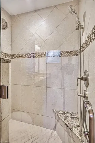Corner Stone Tile and Marble remodeled shower with multiple shower heads, recessed lighting and marble bench