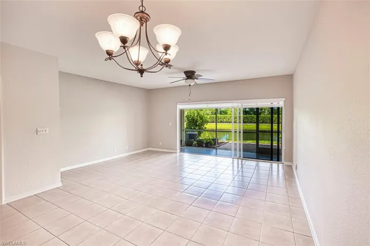 Living/Dining area featuring ceiling fan, a chandelier, light tile patterned flooring, and a textured wall