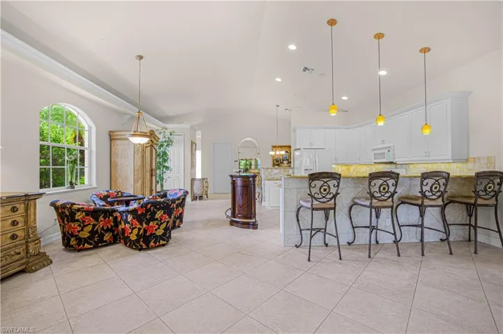 Kitchen with light stone countertops, tasteful backsplash, light tile patterned floors, white cabinetry, and recessed lighting