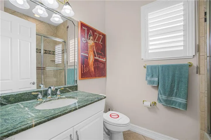 Bathroom with vanity, a shower stall, and tile patterned flooring