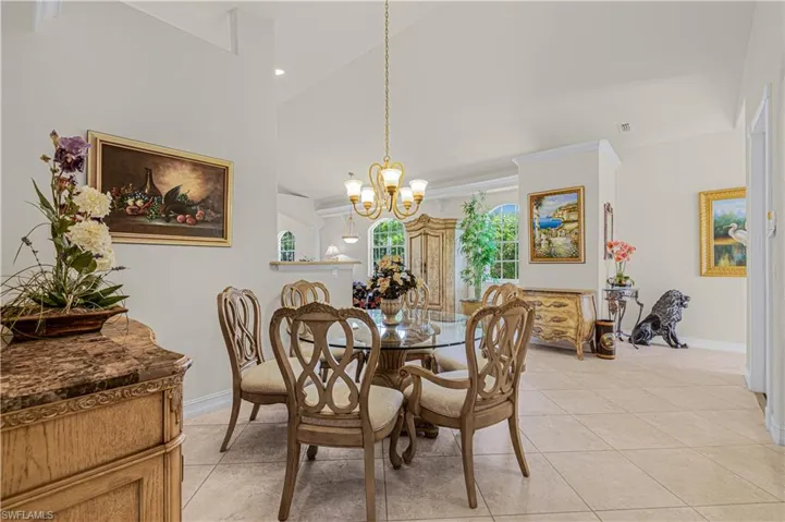 Dining area featuring a chandelier, light tile patterned floors, high vaulted ceiling, and recessed lighting