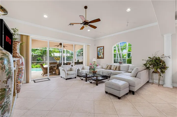 Living room with ceiling fan, light tile patterned floors, ornamental molding, recessed lighting, and ornate columns