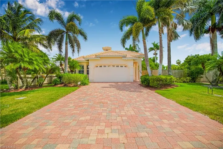 Mediterranean / spanish home featuring decorative driveway, a garage, a tile roof, stucco siding, and a chimney