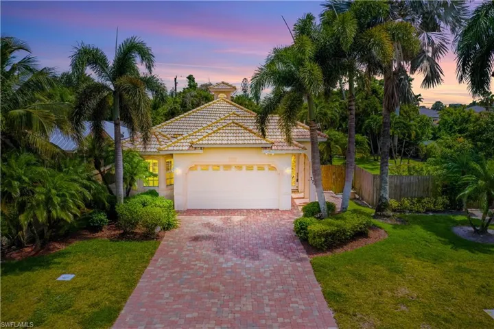 Mediterranean / spanish home with decorative driveway, a garage, stucco siding, and a tile roof