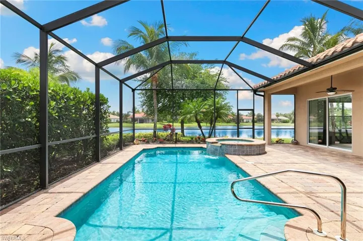 Swimming pool featuring an in-ground hot tub, a patio area, a water view, and a ceiling fan