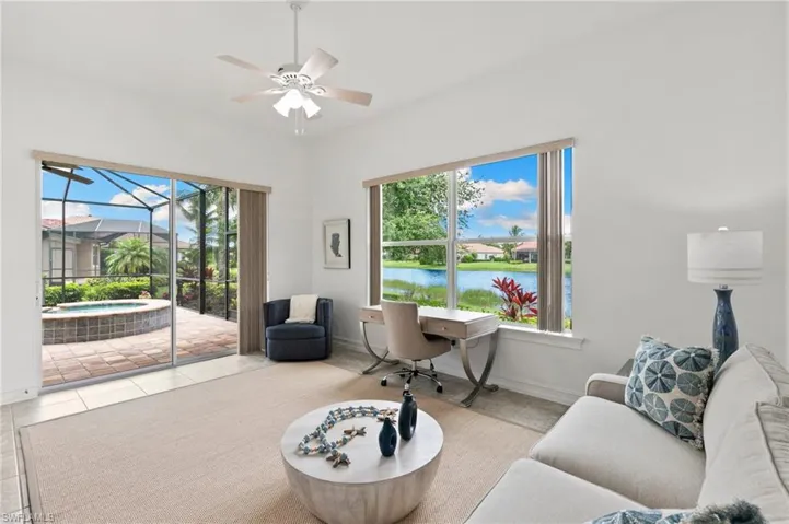 Living area featuring ceiling fan, a water view, a sunroom, and tile patterned flooring