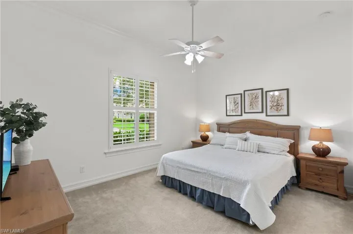Bedroom featuring carpet floors, ornamental molding, and a ceiling fan