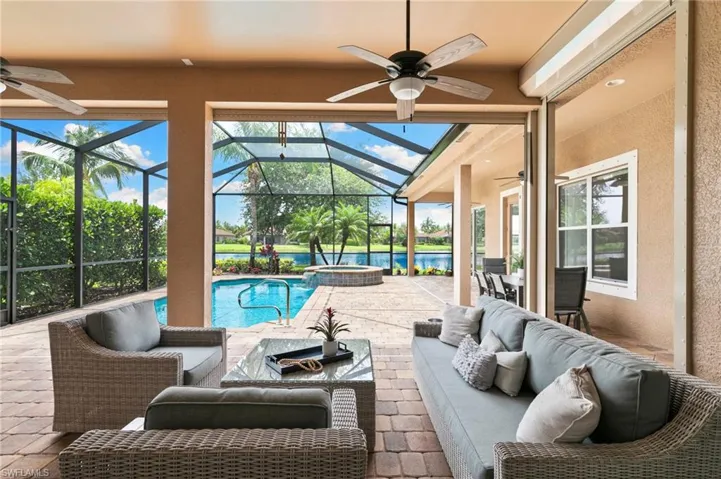 View of patio / terrace featuring a ceiling fan, outdoor lounge area, glass enclosure, and a pool with connected hot tub