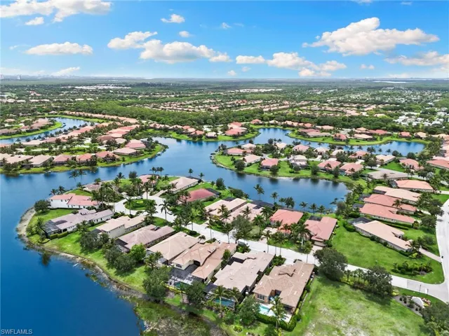 Aerial view of property and surrounding area with nearby suburban area and a large body of water