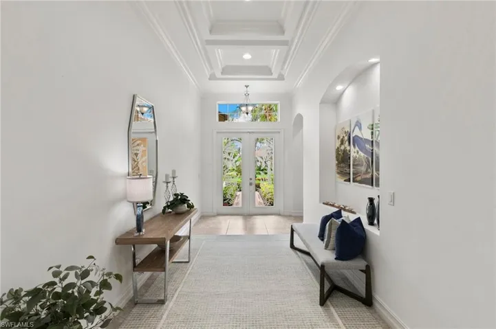 Entrance foyer with french doors, arched walkways, crown molding, recessed lighting, and a tray ceiling