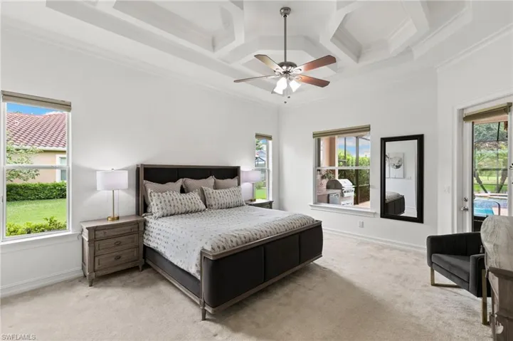 Bedroom with coffered ceiling, ornamental molding, light carpet, access to exterior, and a ceiling fan