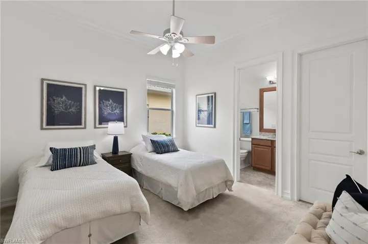 Bedroom featuring crown molding, light colored carpet, ensuite bathroom, and ceiling fan