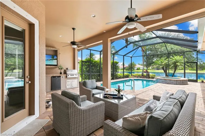 View of patio / terrace featuring ceiling fan, outdoor lounge area, a pool with connected hot tub, and glass enclosure