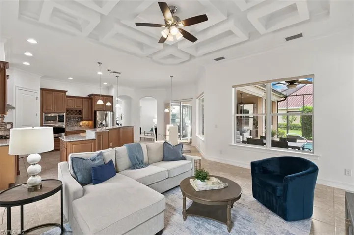 Living area featuring healthy amount of natural light, ceiling fan, light tile patterned floors, arched walkways, and ornamental molding