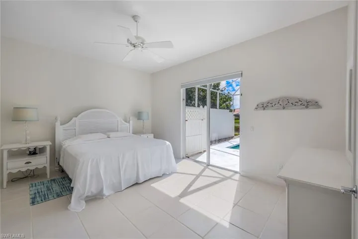 Tiled bedroom featuring ceiling fan and access to outside