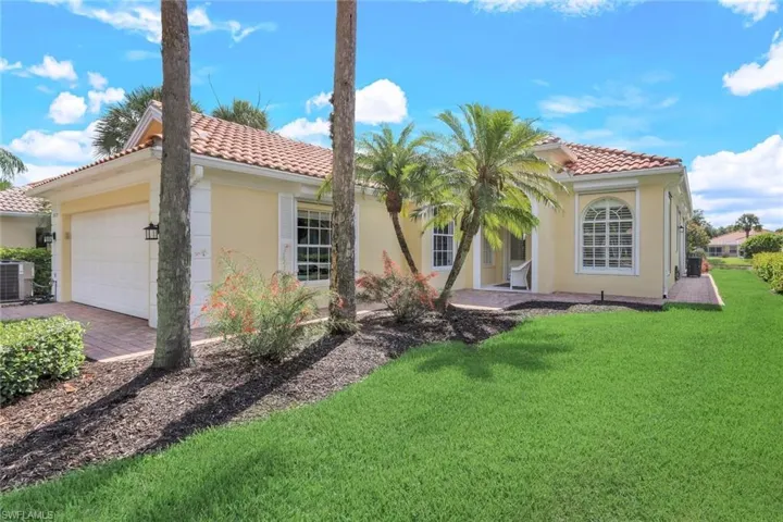 Mediterranean / spanish-style home featuring a garage, a front yard, and central AC unit