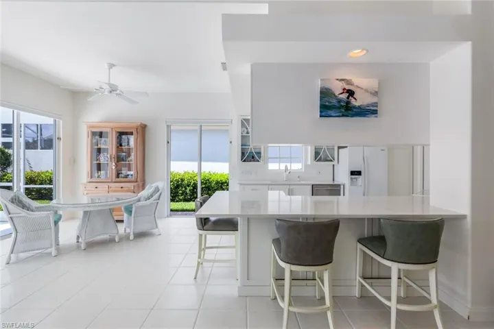 Kitchen with light tile floors, plenty of natural light, and white refrigerator with ice dispenser
