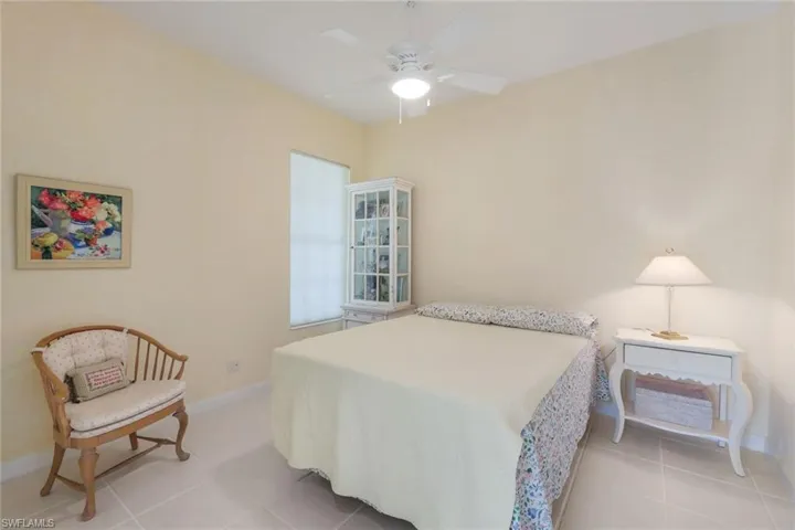 Bedroom with ceiling fan and light tile flooring