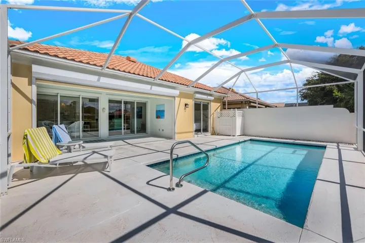 View of swimming pool with a patio and glass enclosure