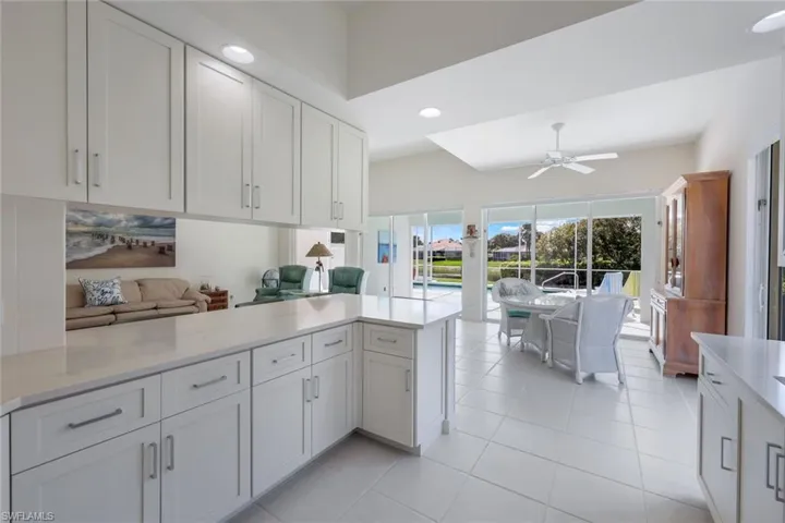 Kitchen featuring white cabinetry, kitchen peninsula, ceiling fan, and light tile floors