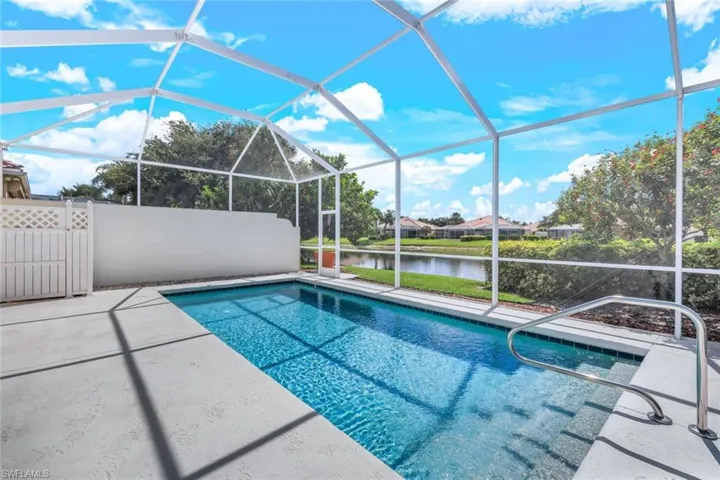 View of swimming pool with a patio area, glass enclosure, and a water view