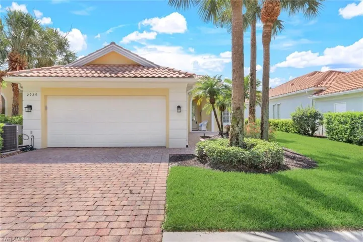Mediterranean / spanish home with a garage, a front yard, and central air condition unit