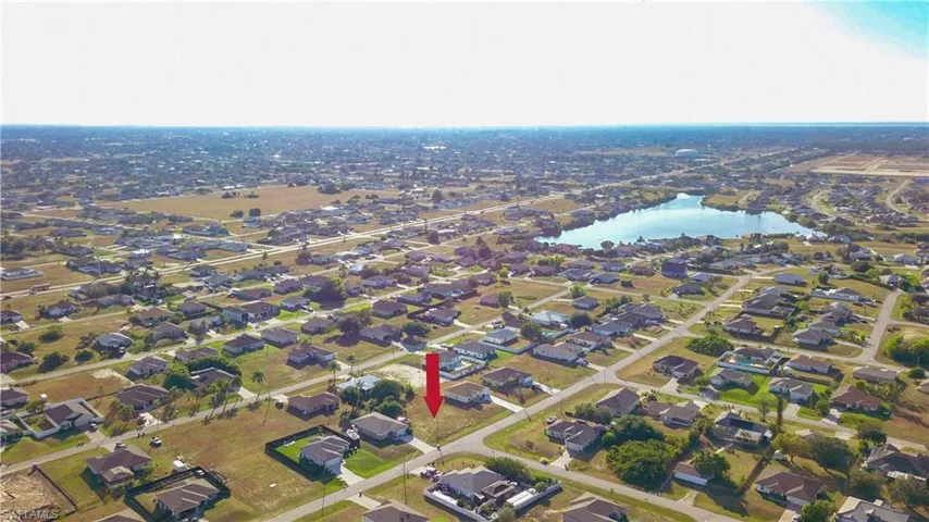 Aerial view of property's location featuring a large body of water and nearby suburban area