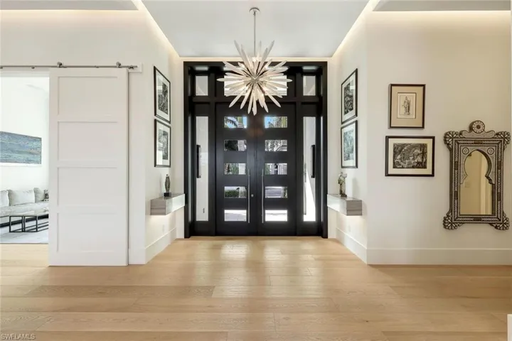 Simply gorgeous entryway with custom doors, light fixture and SO much light!