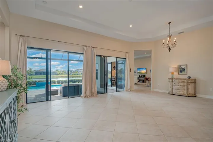 Great room featuring a tray ceiling, suspended lighting, and light tile patterned floors