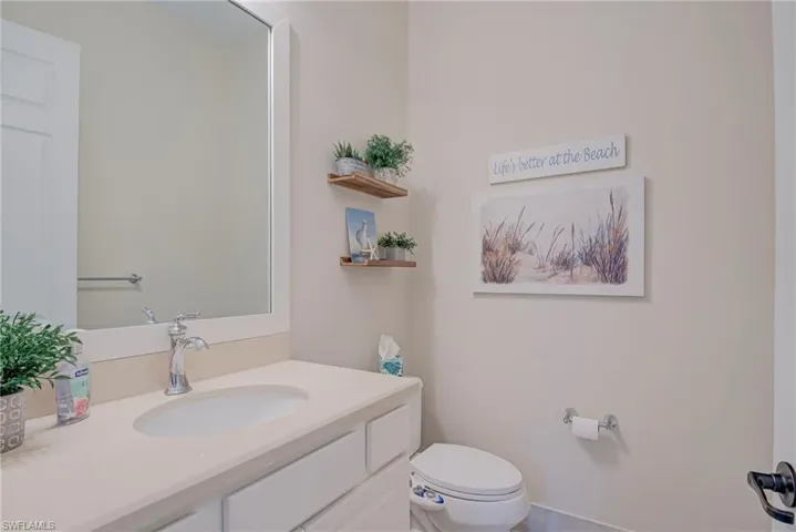 Half bathroom featuring vanity and toilet