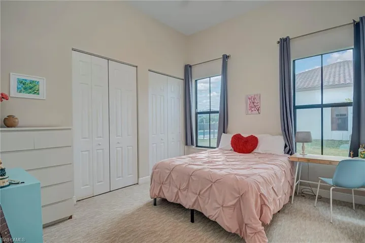Bedroom #2 featuring two closets and light colored carpet