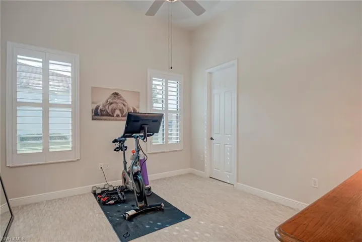 Bedroom #3 with light colored carpet, a ceiling fan, and a high ceiling