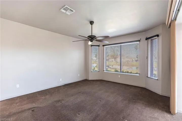 Featuring commercial grade, chocolate carpet and ceiling fan overlooking lake with manual shutters on all three windows